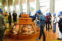 Estudantes observam o funcionamento de uma das turbinas de geração de energia.